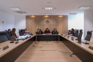 Pessoas sentadas atrás de uma bancada