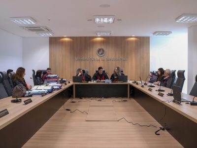 Pessoas sentadas atrás de uma bancada