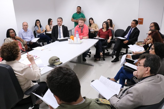 Pessoas reunidas em volta de uma mesa durante reunião