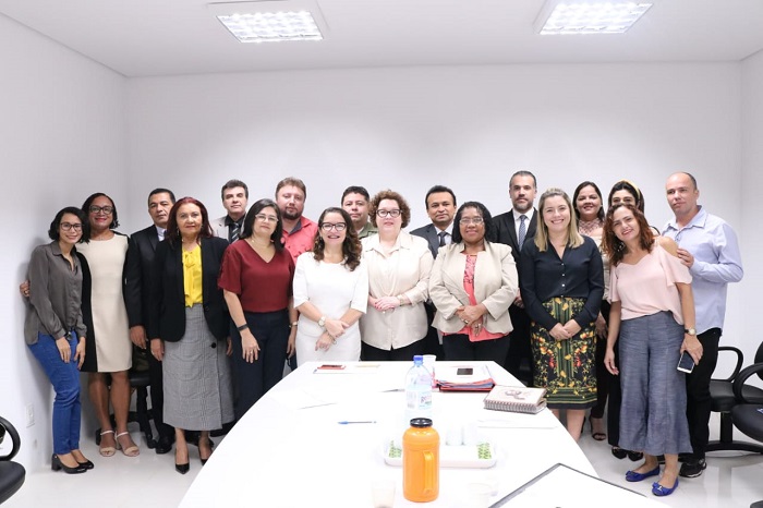 Pessoas de pé sorrindo para foto