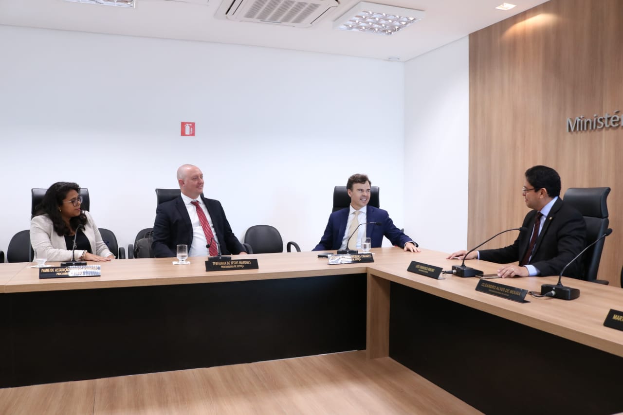Pessoas sentadas em volta de uma bancada 