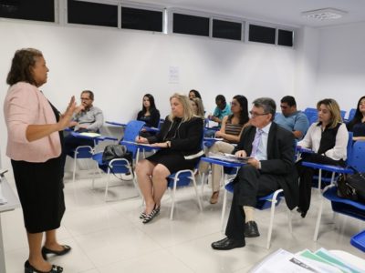 Pessoas sentadas em sala de aula falando com as pessoas que a observam