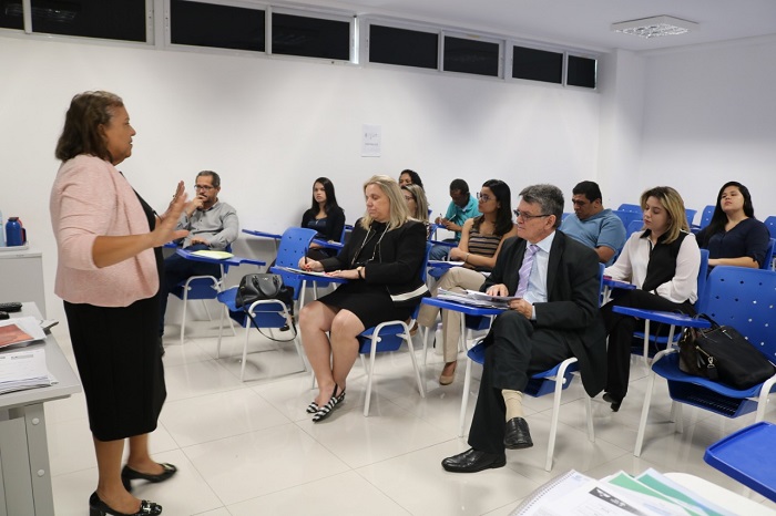 Pessoas sentadas em sala de aula falando com as pessoas que a observam