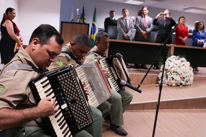 Três homens sentados com instrumentos musicais 