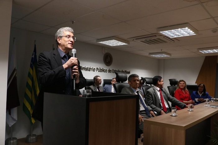 Homem de pé falando para pessoas que o assistem 
