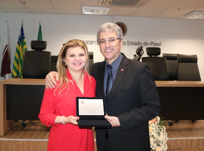 Pessoas de pé sorrindo e segurando um livro 