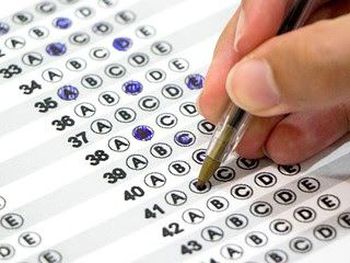 Mão de pessoa preenchendo gabrito de concurso