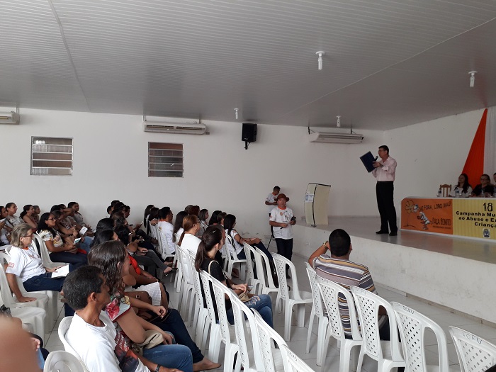 Pessoas sentadas em auditório assistindo palestra 