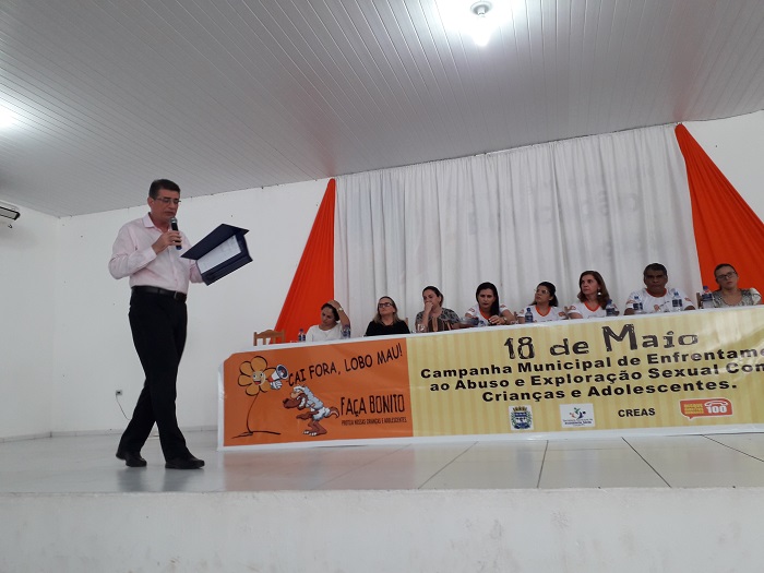 Homem de pé palestrando para o público que está a sua frente 