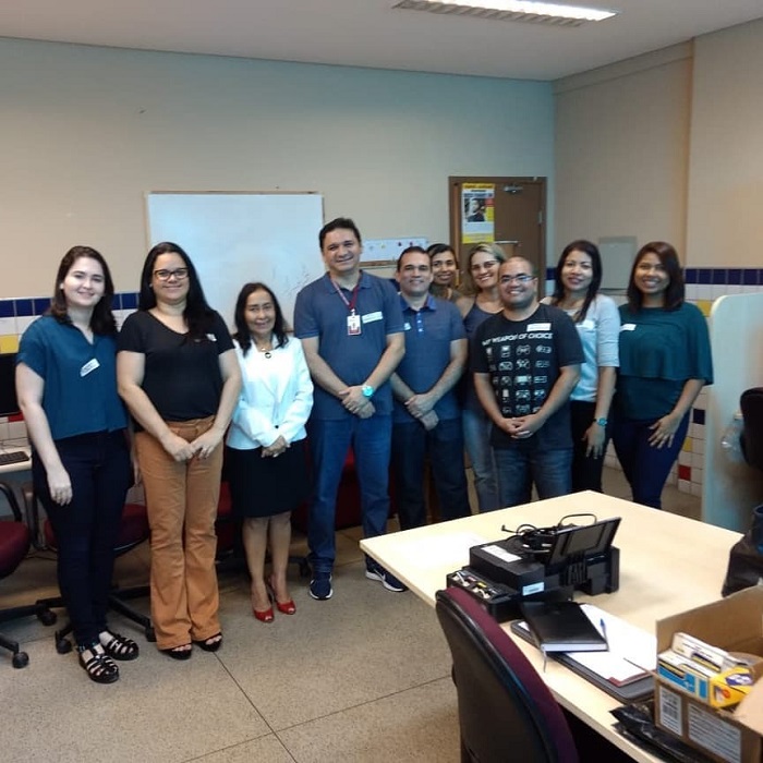 Servidores que integram a comissão organizadora do concurso de pé sorrindo para fotografia 