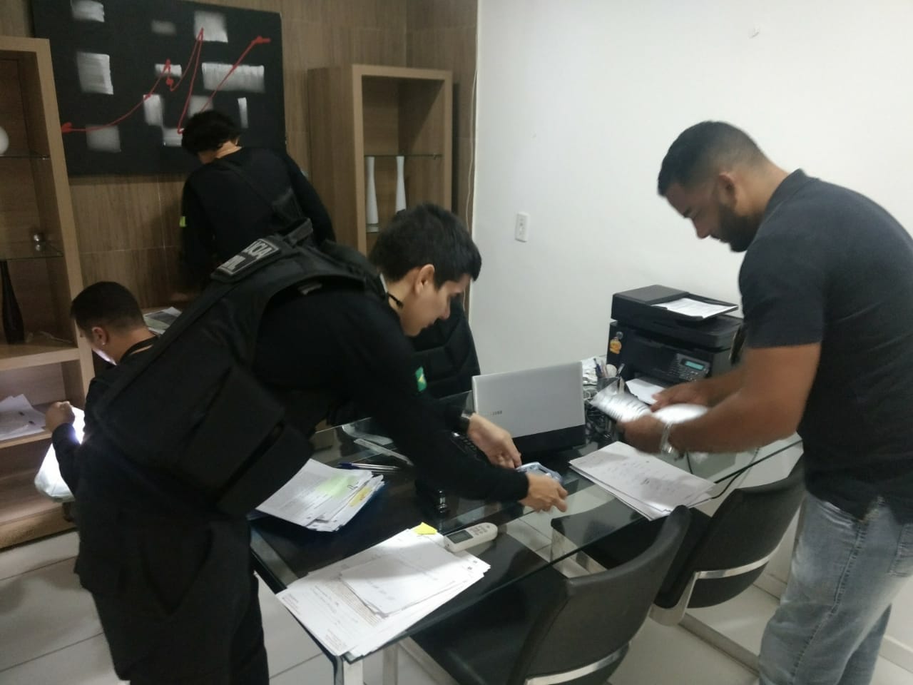 Membros do Grupo durante a Operação Coiote observam documentos em cima de mesa