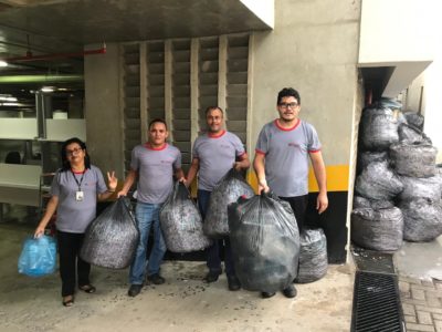 Quatro pessoas de pe segurando sacolas