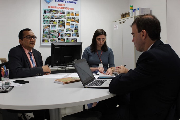 Três pessoas reunidas numa mesa durante reunião