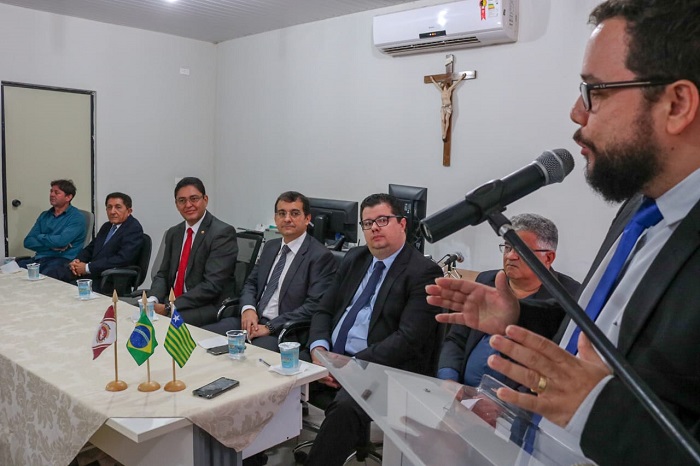 Pessoas sentadas observando homem que está de pé 
