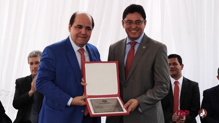 Duas pessoas de pé com uma placa nas mãos