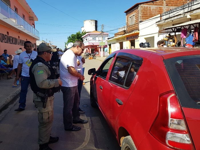 Pessoas entregando material educativo para motociclistas 