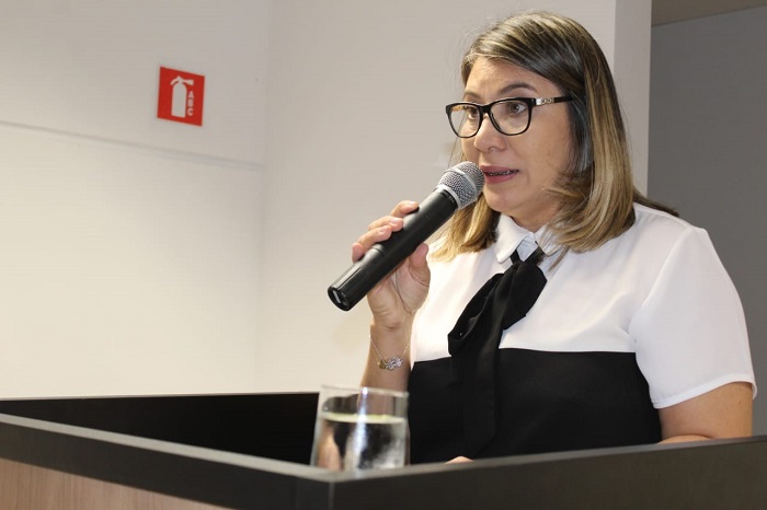 Mulher falando para plateia de auditório 