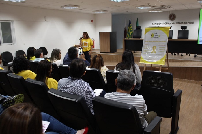 Mulher falando para plateia de auditório 