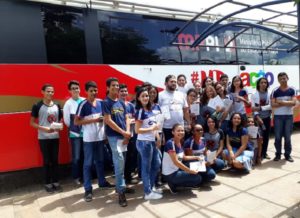 Estudantes posando para foto em frente ao ônibus do Procon Itinerante