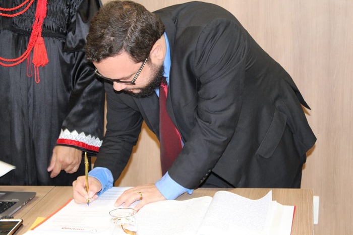Homem assinando documento