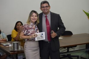 Duas pessoas de pé sorrindo segurando um certificado