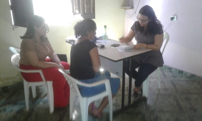 Três pessoas sentadas em volta de uma mesa 