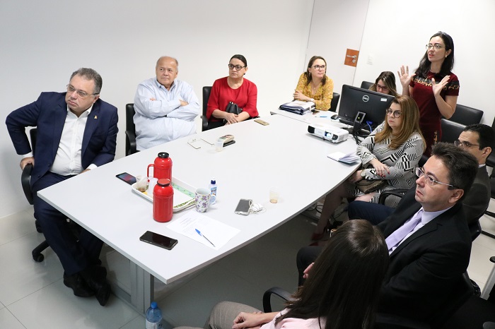 Pessoas sentadas em volta de uma mesa 