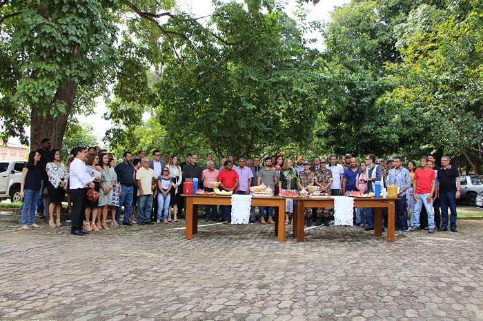 Pessoas de pé em área livre com uma mesa da café da manhã posta na sua frente 
