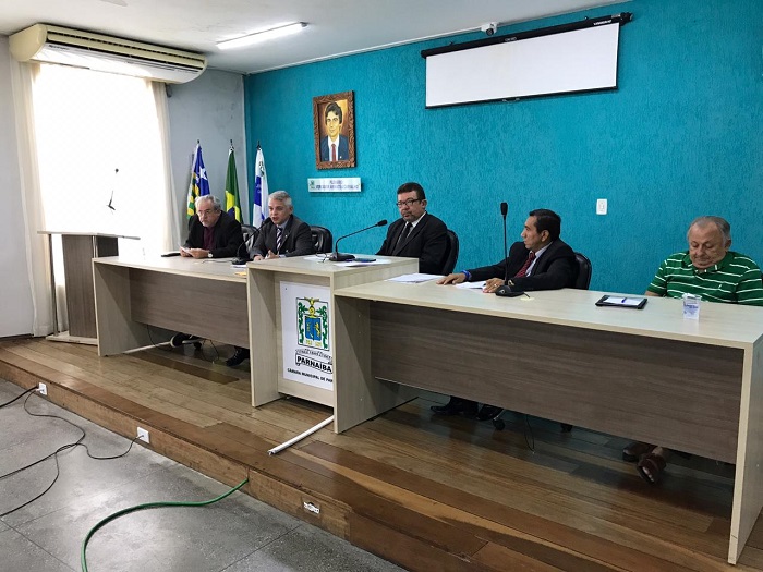 Pessoas sentadas atrás de uma bancada 