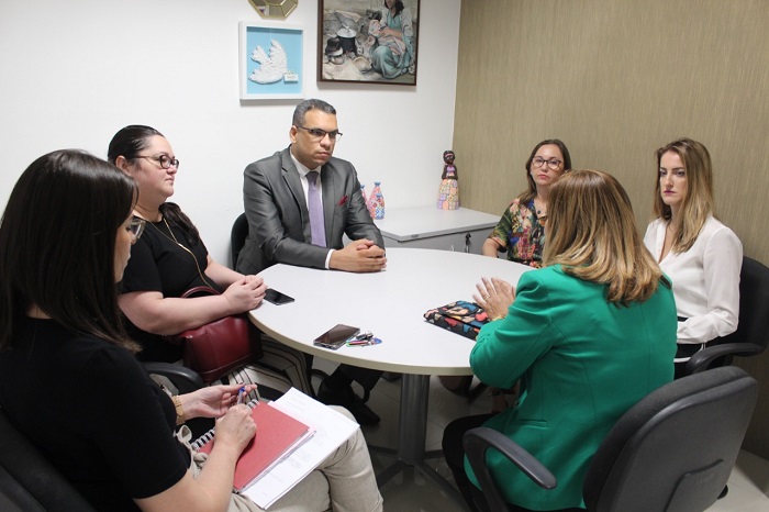 Pessoas sentadas em volta de uma mesa conversando 