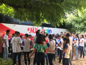 pessoas observando ônibus institucional