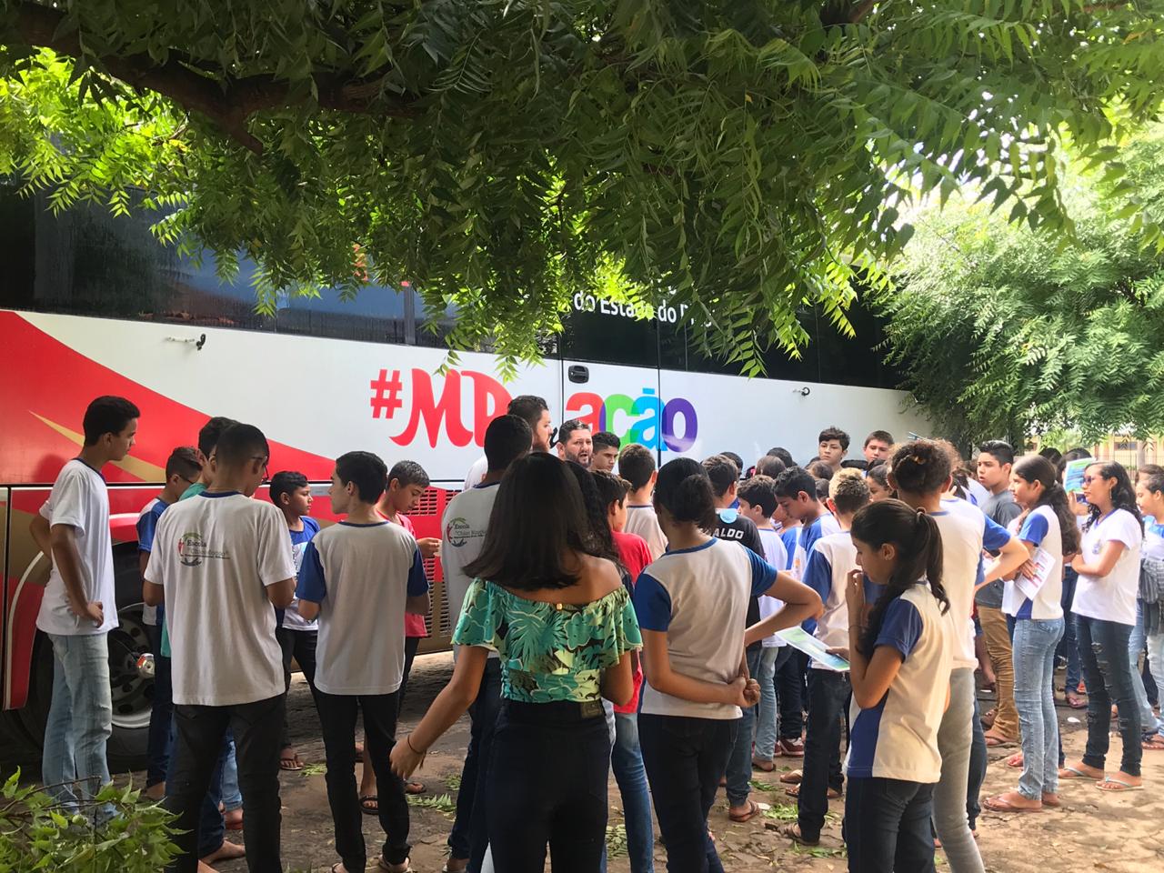 pessoas observando ônibus institucional