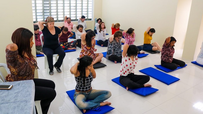 Pessoas sentadas no chão fazendo exercício 