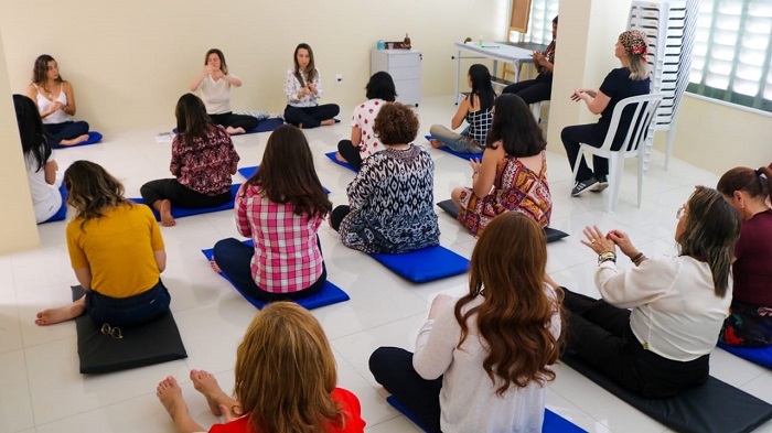 Pessoas sentadas no chão fazendo exercício 