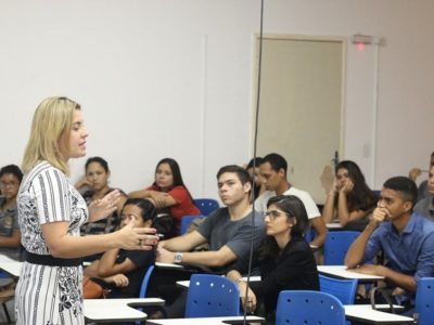 Mulher falando para plateia de auditório