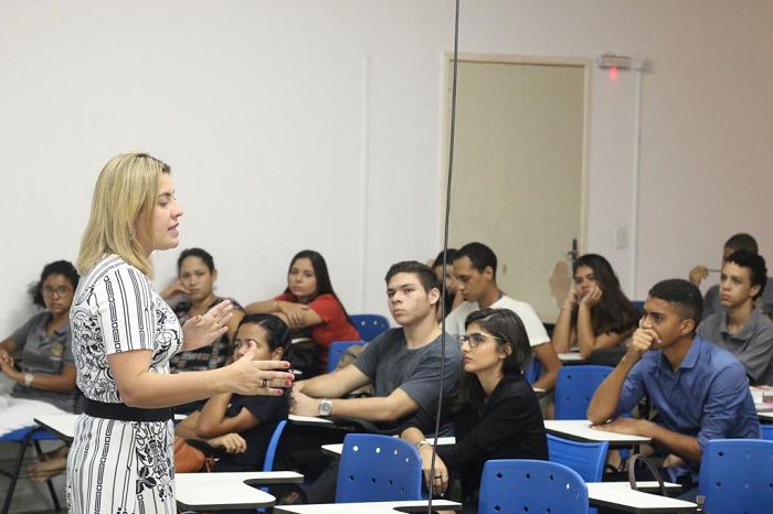 Mulher falando para plateia de auditório