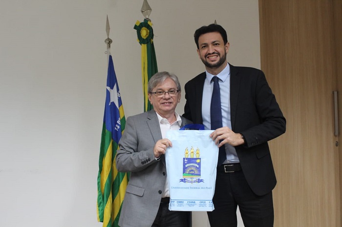 Homens segurando uma sacola e posando para foto