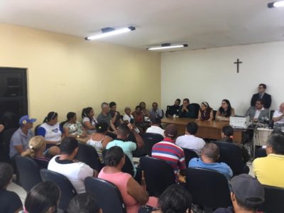 Pessoas sentadas dentro de uma sala de audiência