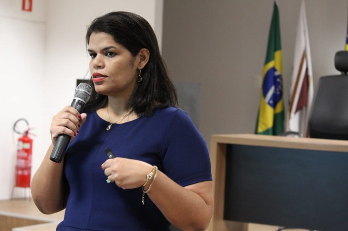 Mulher falando diante de plateia 
