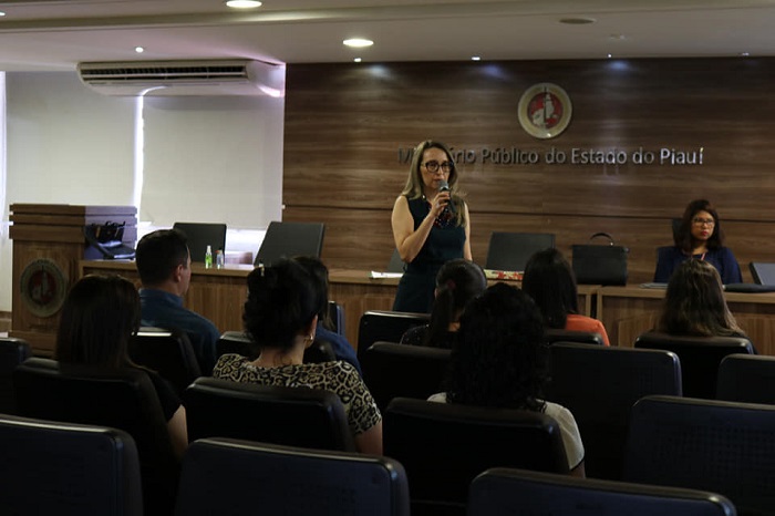 Mulher falando para plateia de auditório 