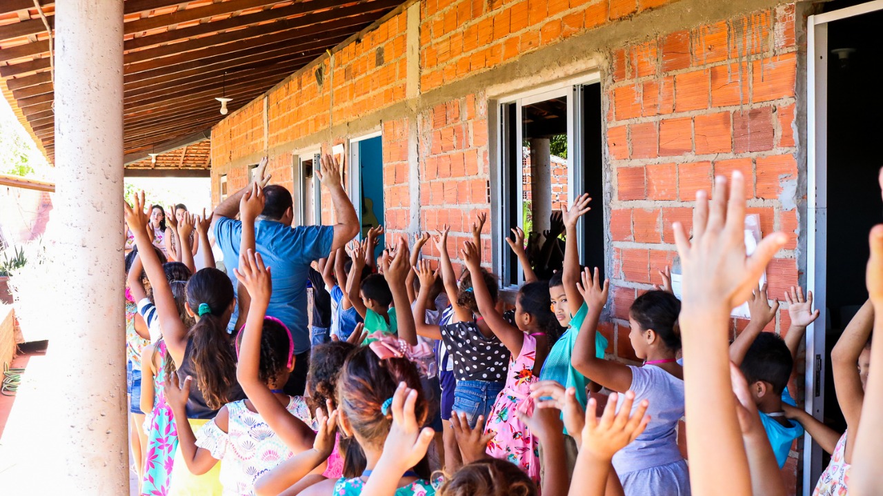 crianças com as mãos levamntadas