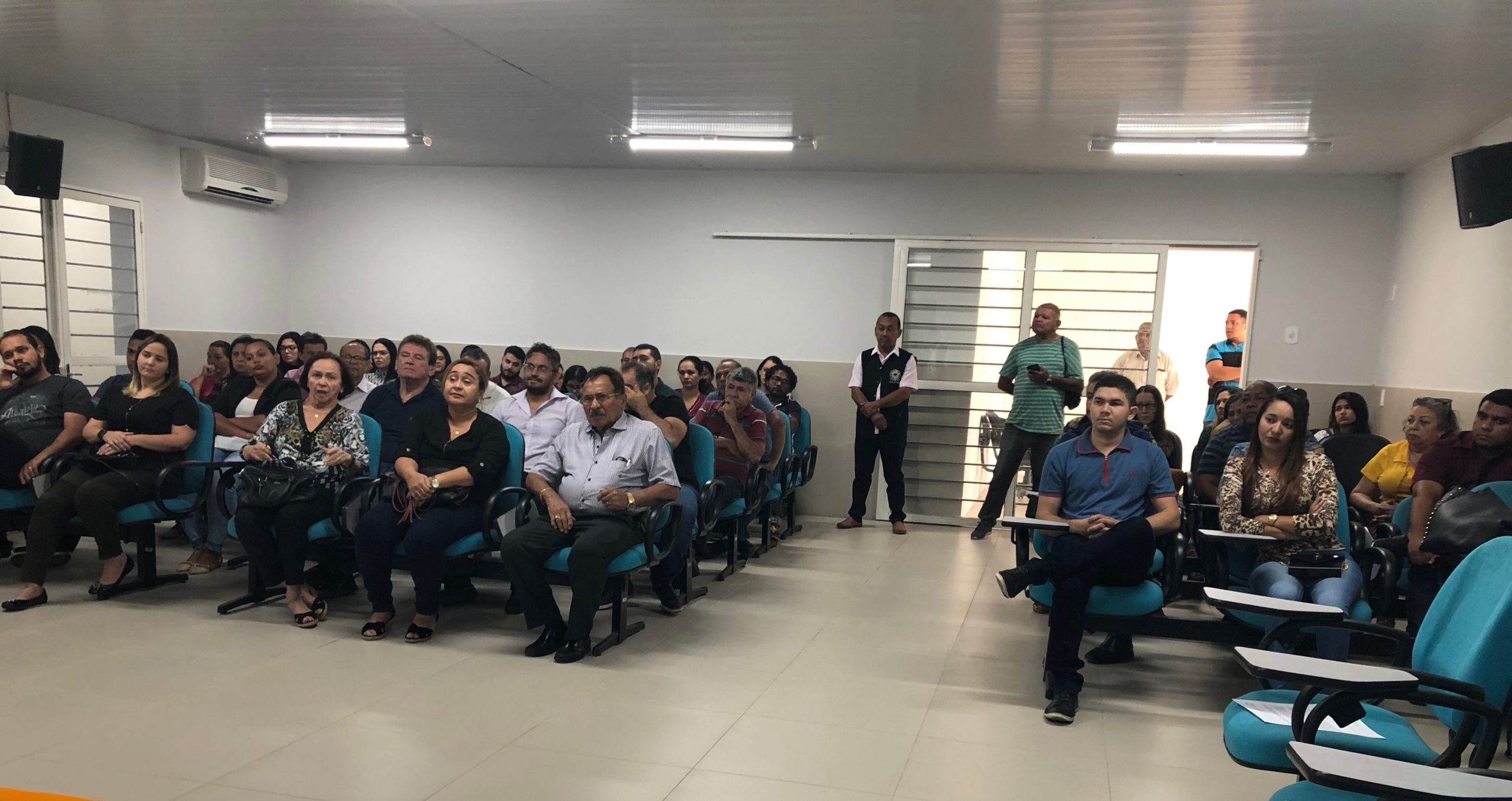 Pessoas sentadas em uma sala de audiência 
