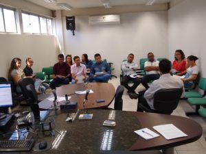 Pessoas sentadas em uma sala de audiência e conversando entre si