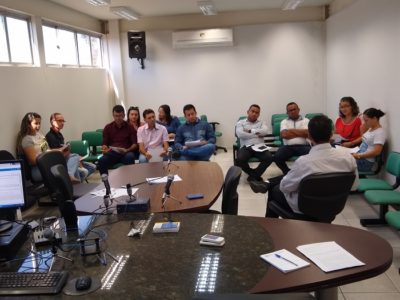 Pessoas sentadas em uma sala de audiência e conversando entre si