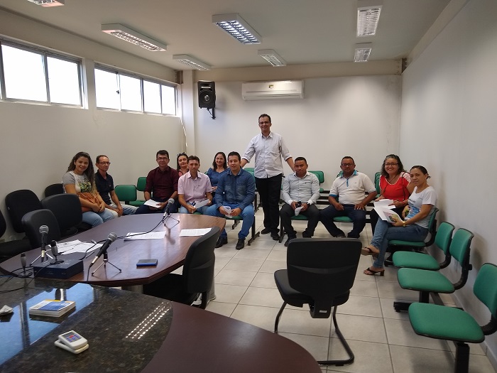Pessoas de pé sorrindo dentro de uma sala 