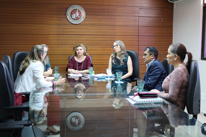 Pessoas sentadas em volta de uma mesa