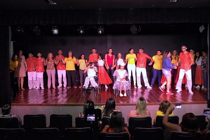 Pessoas de mãos dadas durante apresentação musical