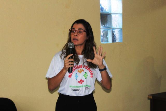 Mulher falando para público diante de plateia