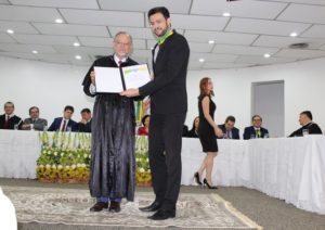 Homem recebendo medalha e homenagem