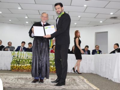 Homem recebendo medalha e homenagem